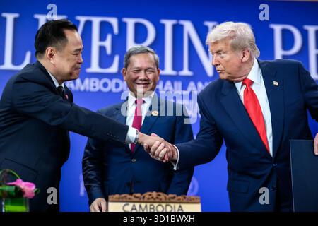 Präsident Donald J. Trump schüttelt dem thailändischen Premierminister Anutin Charnvirakul die Hand, während der kambodschanische Premierminister Hun Manet nach der Unterzeichnung des Friedensabkommens von Kuala Lumpur während des 47. ASEAN-Gipfels in Kuala Lumpur, Malaysia, am Sonntag, den 26. Oktober 2025, die Unterzeichnung des Friedensabkommens von Kuala Lumpur verfolgt. Bild mit freundlicher Genehmigung des Weißen Hauses Stockfoto