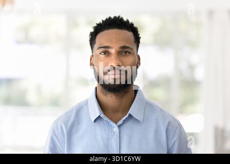 Afrikanischer Mann, der allein auf sonnigem, verschwommenem Hintergrund steht Stockfoto