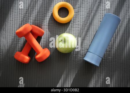 Fitnessgeräte und gesunde Snacks auf der Trainingsmatte Stockfoto