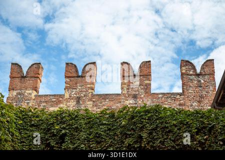 Schwalbenschwanzmauern oder Merlons und rotes Ziegelwerk von Castelvecchio, einer mittelalterlichen Burg in Verona, Italien, mit befestigter Architektur und dem h Stockfoto