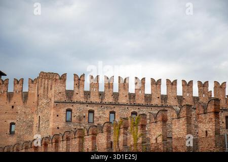 Schwalbenschwanzmauern oder Merlons und rotes Ziegelwerk von Castelvecchio, einer mittelalterlichen Burg in Verona, Italien, mit befestigter Architektur und dem h Stockfoto