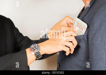 Geschäftsmann, der seinem Partner Geld gibt, während er einen Vertrag schließt – Konzepte für Bestechung und Korruption. Nahaufnahme von der Seite. Stockfoto
