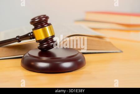 Recht und Gerechtigkeit. Hölzerner richterlicher Hammer mit Dokumenten und Gesetzbüchern im Gerichtssaal, Nahansicht. Kopierbereich Stockfoto