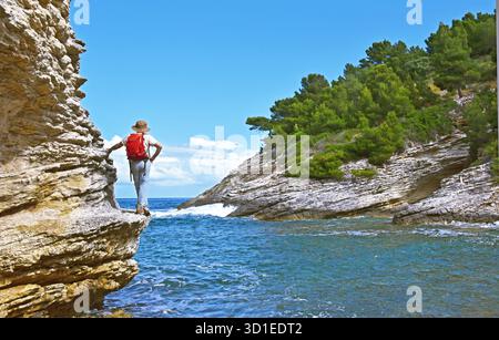 Wanderer auf dem Küstenweg entlang der steilen felsigen Küste, Frankreich, Korsika, Patrimonio Stockfoto
