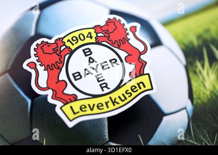 KIEW, UKRAINE - 23. FEBRUAR 2025 Bayer 04 Leverkusen Fußballklub-Abzeichen liegt auf einem Fußball-Hintergrund-Banner Stockfoto