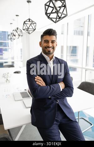 Positiver indischer Geschäftsführer posiert für vertikales Porträt Stockfoto