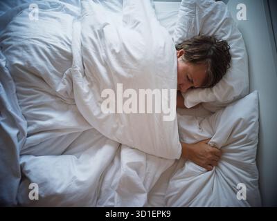 Einsame 35-jährige Frau, die nach Trennung allein schläft, Traurigkeit und emotionaler Leere Stockfoto