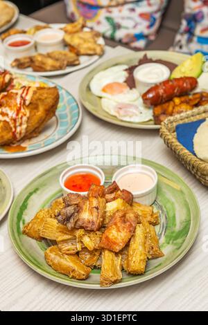 Knusprige, doppelt gekochte, gebratene Yuca-Sticks mit scharfer Koriander-Sauce und zerbröckeltem Queso-Fresko Stockfoto
