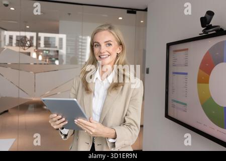 Glückliche blonde junge Geschäftsfrau posiert für Porträt Stockfoto