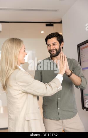 Fröhliche, erfolgreiche junge Geschäftskollegen, die an einem Projekt arbeiten Stockfoto