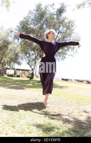 Junge Frau tanzt frei in der Natur draußen Stockfoto