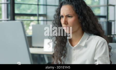 Besorgte verwirrte hispanische Geschäftsfrau, die schlechte Nachrichten auf dem Computer liest, verwirrt mit Online-Arbeitsaufgabe Geschäftsfrau ethnische weibliche weibliche Arbeitermanagerin Stockfoto
