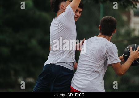 Zwei Männer spielen im Freien Basketball, intensive Momente, Teamarbeit und Wettkämpfe auf dem Platz Stockfoto