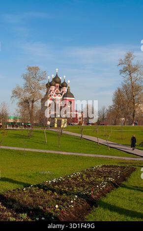 Moskau, Russland: Frau, die im Aleksejewski-Park spaziert, mit Blick auf den Tempel zu Ehren der Tichvin-Ikone unserer Lieben Frau, berühmte russisch-orthodoxe Kirche Stockfoto