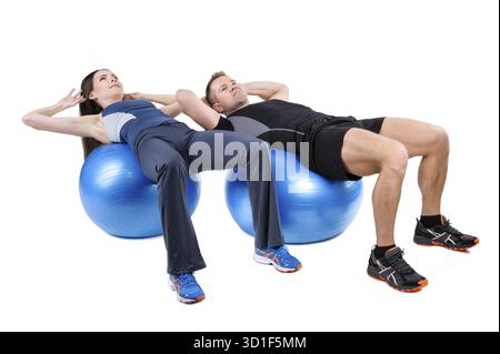 Das junge Paar zeigt die Ausgangsposition des Bauchfitball-Workouts, isoliert auf weiß Stockfoto