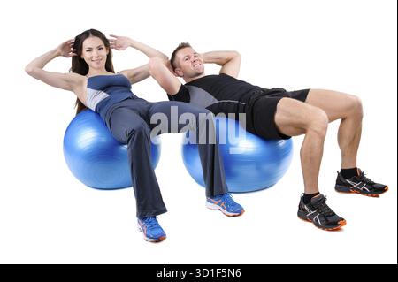 Das junge Paar zeigt die Ausgangsposition des Bauchfitball-Workouts, isoliert auf weiß Stockfoto
