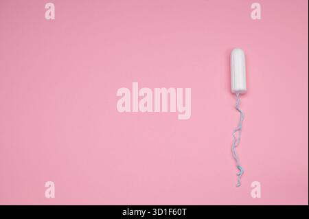 Sauberer Tampon auf glatter rosafarbener Oberfläche mit Schnur. Stockfoto