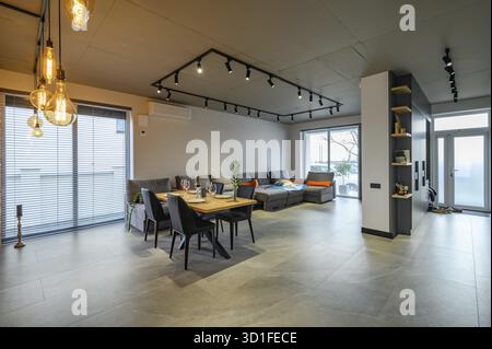 Modernes, luxuriöses Studio-Apartment mit Esstisch im großen Wohnzimmer Stockfoto
