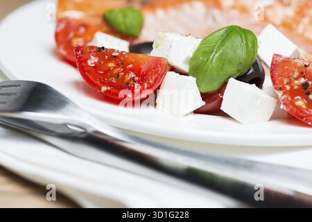 Gegrillter Lachs und griechischer Salat auf Teller Stockfoto