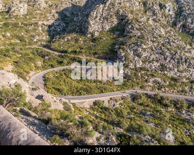 Serpentinenstraße nach Sa Calobra, Mallorca, schlängelt sich die Straße durch zerklüftete, felsige Berge mit spärlich grüner Vegetation und bietet eine malerische Fahrt, Ma Stockfoto