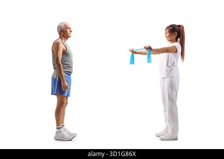Profilaufnahme eines Sporttrainers in voller Länge, der einem älteren Mann eine Übung zeigt, isoliert auf weißem Hintergrund Stockfoto