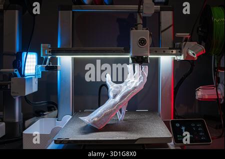 Eine 3D-gedruckte Hand entsteht aus einem Drucker und zeigt fortschrittliche Handwerkskunst und Innovation Stockfoto