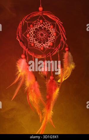 Schöner Traumfänger und Rauch in Farbe hell auf dunklem Hintergrund Stockfoto