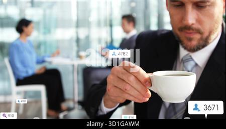 Trinken Sie Kaffee aus weißer Keramikschale, Mann im Anzug in der Lounge, mit schwebenden Verlobungssymbolen Stockfoto