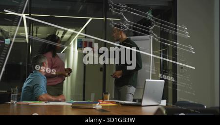 Mann mit Gesten in Richtung Flipchart-Farbmuster im Besprechungsraum mit Laptop-Markierungen Stockfoto