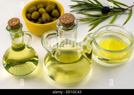 Behälter mit Olivenöl und grünen Oliven Stockfoto