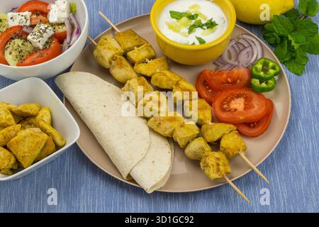 Gericht mit Hühnersouvlaki, griechischem Salat und Tzatziki-Sauce Stockfoto