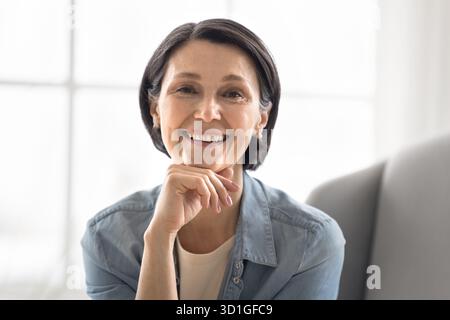 Kopffoto-Porträt ziemlich lächelnde reife Frau, die in die Kamera schaut Stockfoto