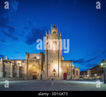 Die Kathedrale von Palencia leuchtet in der Abenddämmerung auf der Plaza de la Inmaculada, der beleuchtete Glockenturm und das skulpturale Portal sorgen für einen atemberaubenden Anblick. Stockfoto