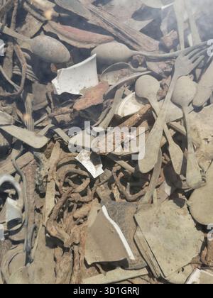 Scheren, Schmuckstücke, wertvolle Gegenstände und Utensilien, die buchstäblich in den Boden der Kanada-Kaserne von Auschwitz-Birkenau eingebettet sind – heute unter Glas aufbewahrt. Stockfoto