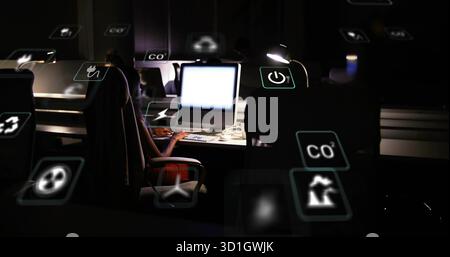 Überwachung von Ökometriken weibliche Ingenieurin, die nachts im Büro am Computer arbeitet, mit schwebenden Symbolen Stockfoto