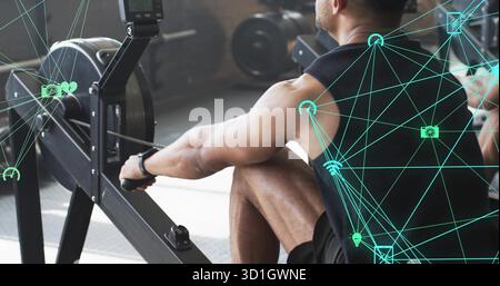 Ziehender Mann mit schwarzem ärmellosem Top-Ruderergometer in der Nähe von Gewichtsplatten im modernen Fitnessstudio Stockfoto