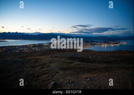 Blick von Storsteinen, atemberaubender abendlicher Blick auf Tromso, Norwegen mit Bergen im Hintergrund, beleuchtet von der untergehenden Sonne, auf der Spitze von Storste Stockfoto