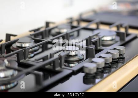 Nahaufnahme eines integrierten 5-Flammen-Gaskochfelds aus schwarzem Glas. Selektiver Fokus. Stockfoto