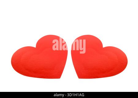 Ein auffälliges Bild von zwei leuchtend roten Papierherzen, die nebeneinander stehen und Liebe, Romantik und Partnerschaft symbolisieren. Stockfoto