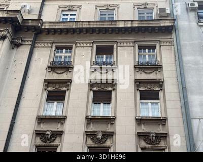 Historische Steinfassade mit kunstvollen Ornamenten und Fenstern. Klassische Architektur, europäisches Erbe und urbane Eleganz im Stadtzentrum. Stockfoto