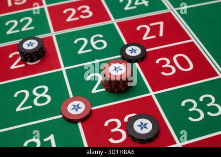 GLÜCKSSPIEL, GENERISCHER ROULETTE-TISCH, CHIPS, STRATEGIE: Ein klassischer Roulette-Tisch von Spieler POV mit Chips, die in einer gemeinsamen Wettstrategie in einem Live-Casino angeordnet sind. Stockfoto