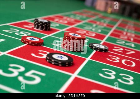 GLÜCKSSPIEL, GENERISCHER ROULETTE-TISCH, CHIPS, STRATEGIE: Ein klassischer Roulette-Tisch von Spieler POV mit Chips, die in einer gemeinsamen Wettstrategie in einem Live-Casino angeordnet sind. Stockfoto
