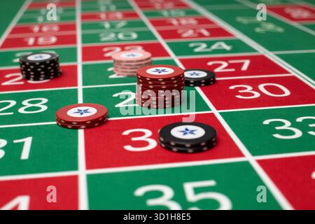 GLÜCKSSPIEL, GENERISCHER ROULETTE-TISCH, CHIPS, STRATEGIE: Ein klassischer Roulette-Tisch von Spieler POV mit Chips, die in einer gemeinsamen Wettstrategie in einem Live-Casino angeordnet sind. Stockfoto