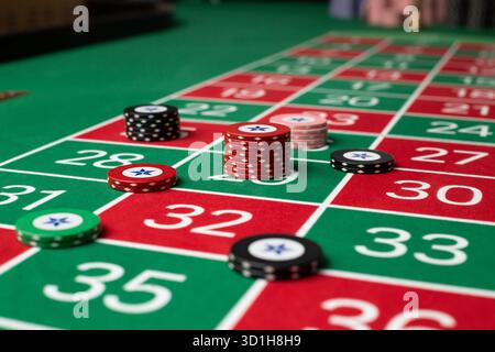 GLÜCKSSPIEL, GENERISCHER ROULETTE-TISCH, CHIPS, STRATEGIE: Ein klassischer Roulette-Tisch von Spieler POV mit Chips, die in einer gemeinsamen Wettstrategie in einem Live-Casino angeordnet sind. Stockfoto