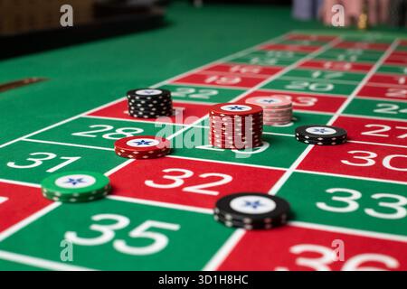 GLÜCKSSPIEL, GENERISCHER ROULETTE-TISCH, CHIPS, STRATEGIE: Ein klassischer Roulette-Tisch von Spieler POV mit Chips, die in einer gemeinsamen Wettstrategie in einem Live-Casino angeordnet sind. Stockfoto