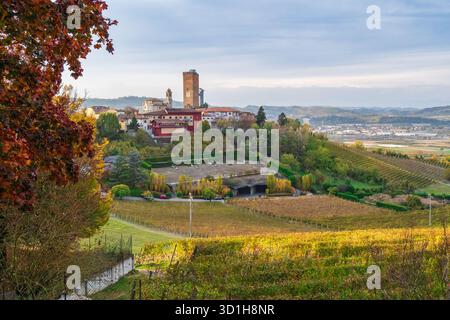 Herbstberge und historisches Dorf auf einem Hügel in Langhe, Piemont, Italien. Malerische Weinregion, UNESCO-Landschaft, Reise- und Landwirtschaftsziel in Stockfoto