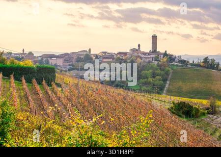 Herbstberge und historisches Dorf auf einem Hügel in Langhe, Piemont, Italien. Malerische Weinregion, UNESCO-Landschaft, Reise- und Landwirtschaftsziel in Stockfoto