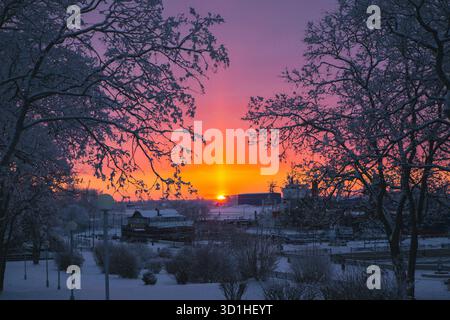 Ein wunderschöner Sonnenuntergang, der warme Farbtöne über einem schneebedeckten Raum ausstrahlt Stockfoto