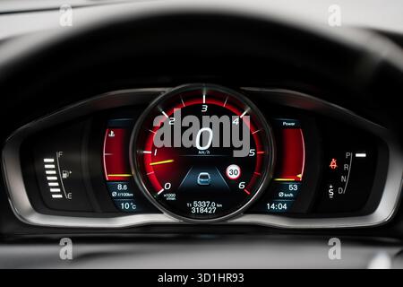 Modernes digitales Armaturenbrett mit beleuchtetem Tachometer und elektronischem Display, das Kraftstoffstand, Temperatur und Fahrmodusanzeigen in High-Re anzeigt Stockfoto