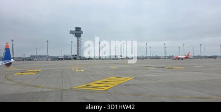 Doloman, Türkei - 25. April 2025: Die Start- und Landebahn des Flughafens verfügt über einen Kontrollturm und geparkte Flugzeuge auf dem Rollfeld. Stockfoto